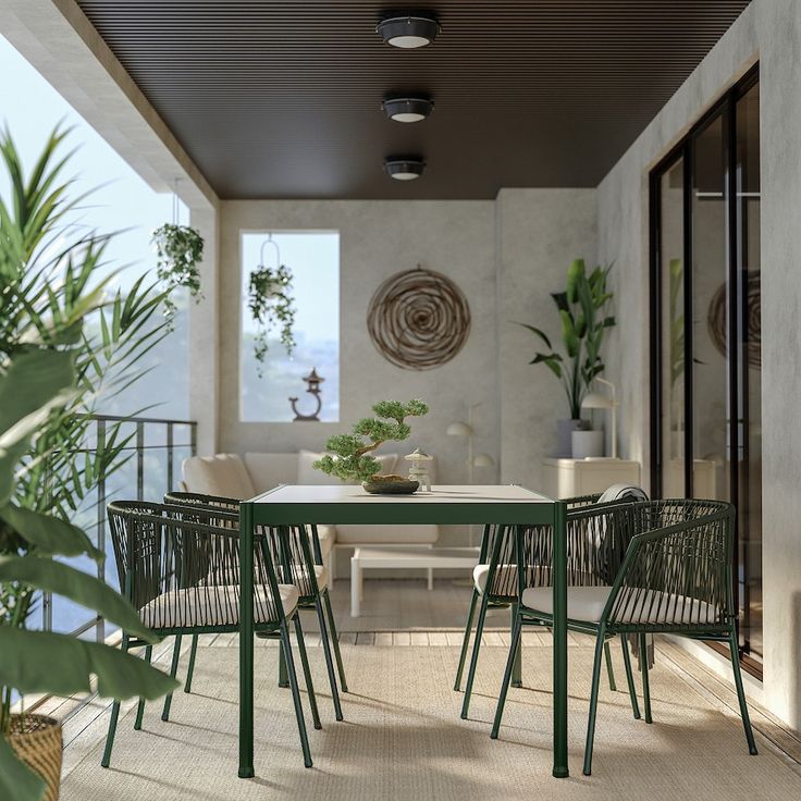 an outdoor dining area with wicker chairs and white table surrounded by potted plants