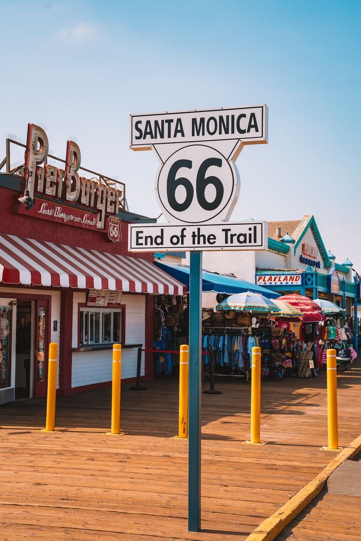 a street sign in front of a store called santa monica 66 and end of the trail