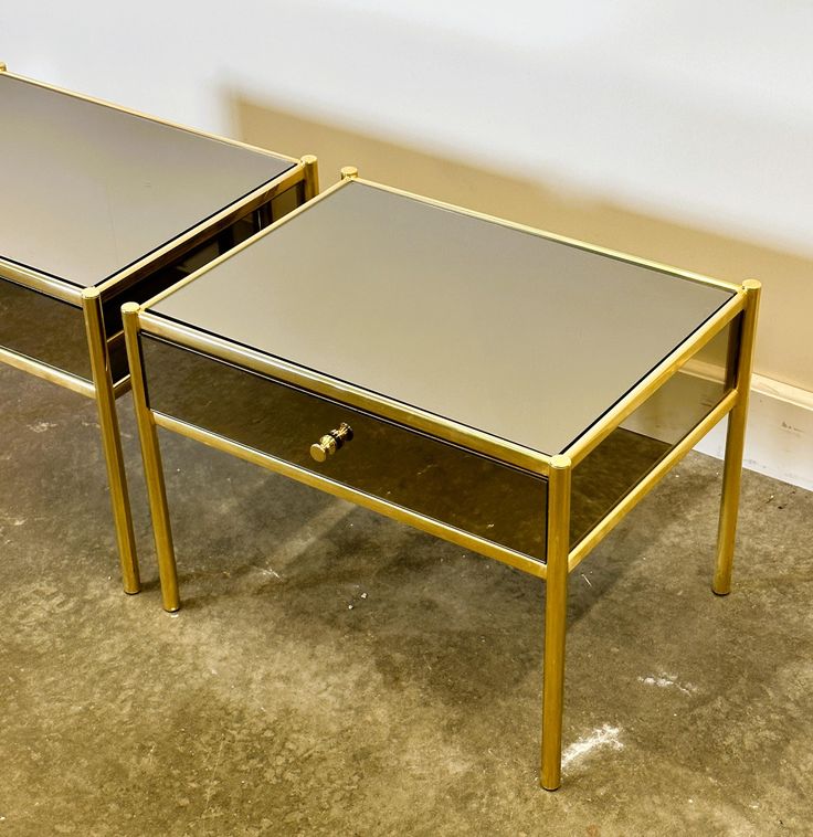 two mirrored side tables sitting on top of a carpeted floor