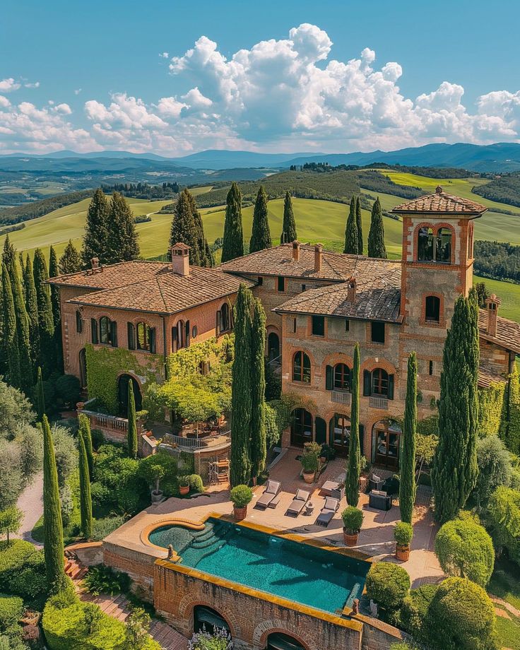 an aerial view of a large home surrounded by trees and greenery with a swimming pool in the foreground