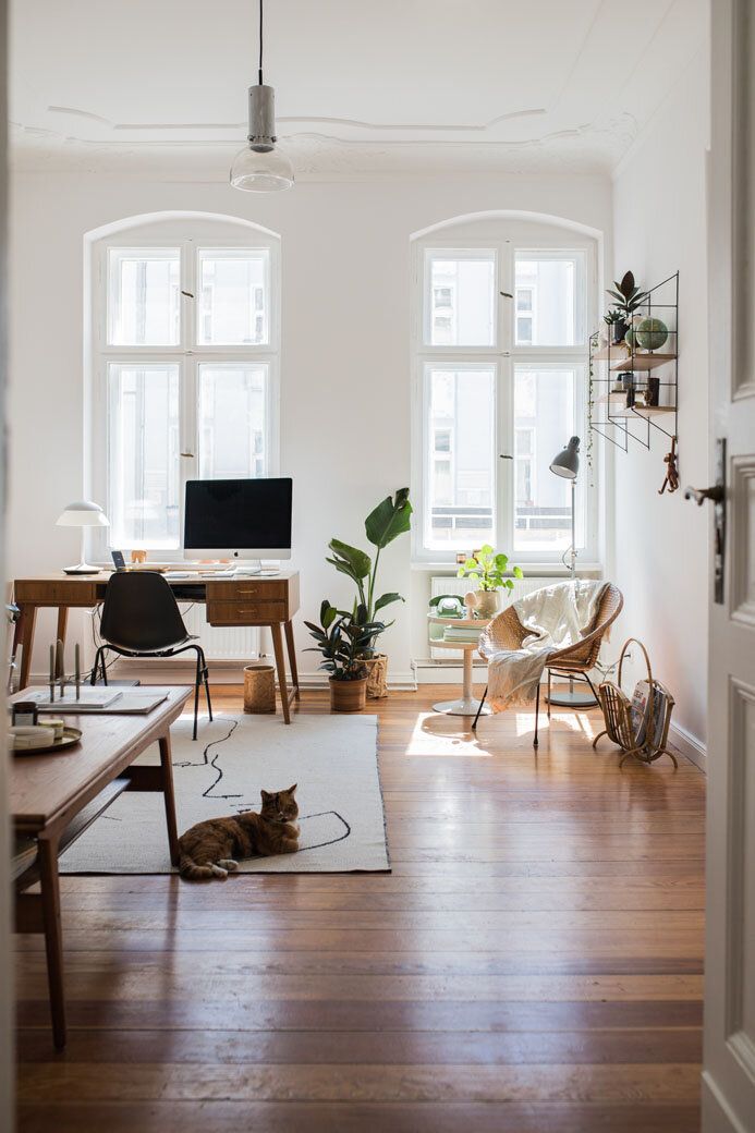 a dining room table with chairs and potted plants on the shelf next to it