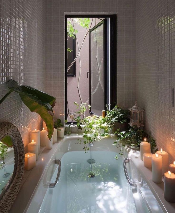 an indoor hot tub surrounded by candles and plants