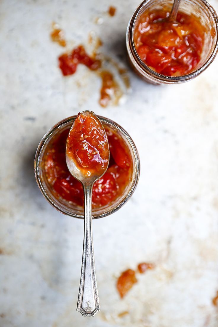 two spoons filled with sauce on top of a table