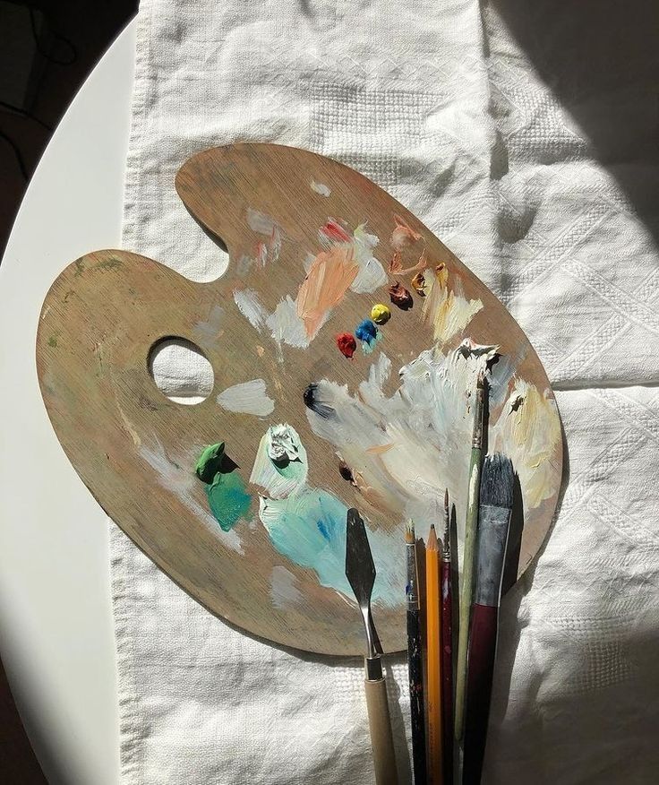 an artist's palette with paint and brushes