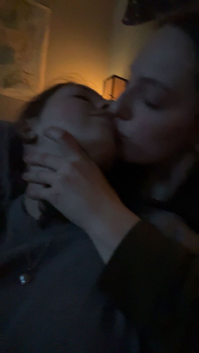 a man and woman kissing each other in the dark