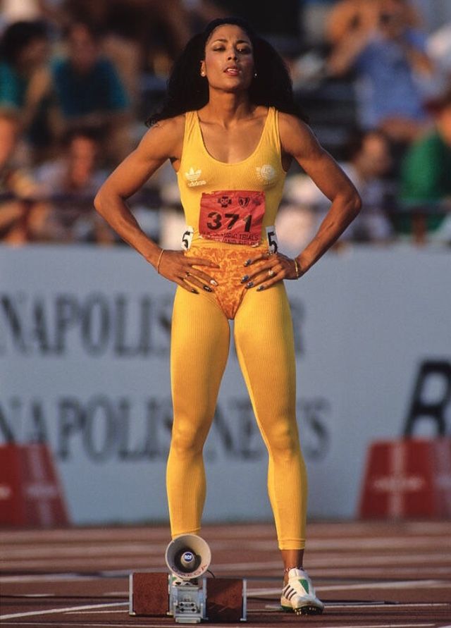 a woman standing on top of a track with her hands on her hips