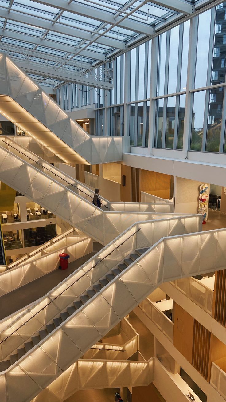 In the image we see a multitude of intertwined staircases with white railings and lights. All the staircases are slightly crossing each other and are illuminated with warm light. Rotterdam Netherlands, Aesthetic Apartment, Somewhere Only We Know, Vision Board Pictures, College Aesthetic, Uni Life, University Life, Applied Science, Staircases