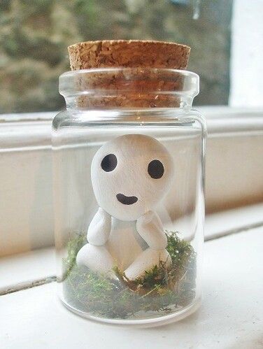 a glass jar with a small white figurine in it