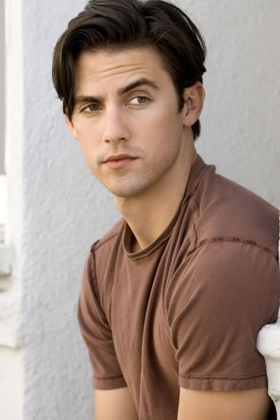 a young man sitting on the ground with his eyes wide open and looking into the distance