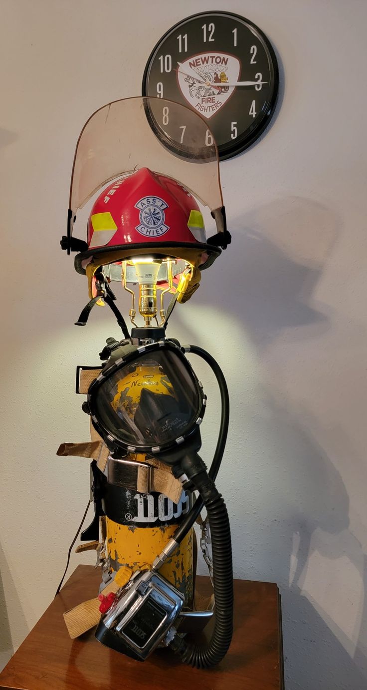 a fireman's helmet sitting on top of a table next to a clock