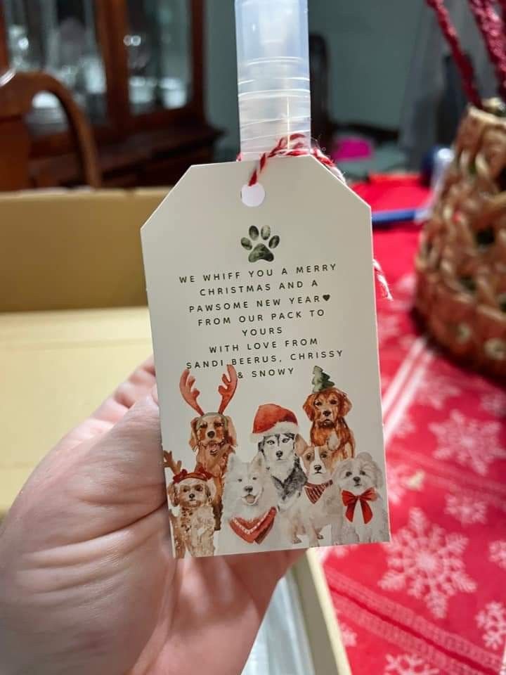 someone is holding up a christmas gift tag with dogs on it and the words, we wish you a merry christmas and happy new year from our dog