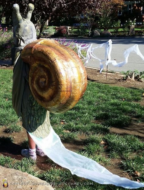 a statue in the shape of a snail holding a piece of cloth on it's back