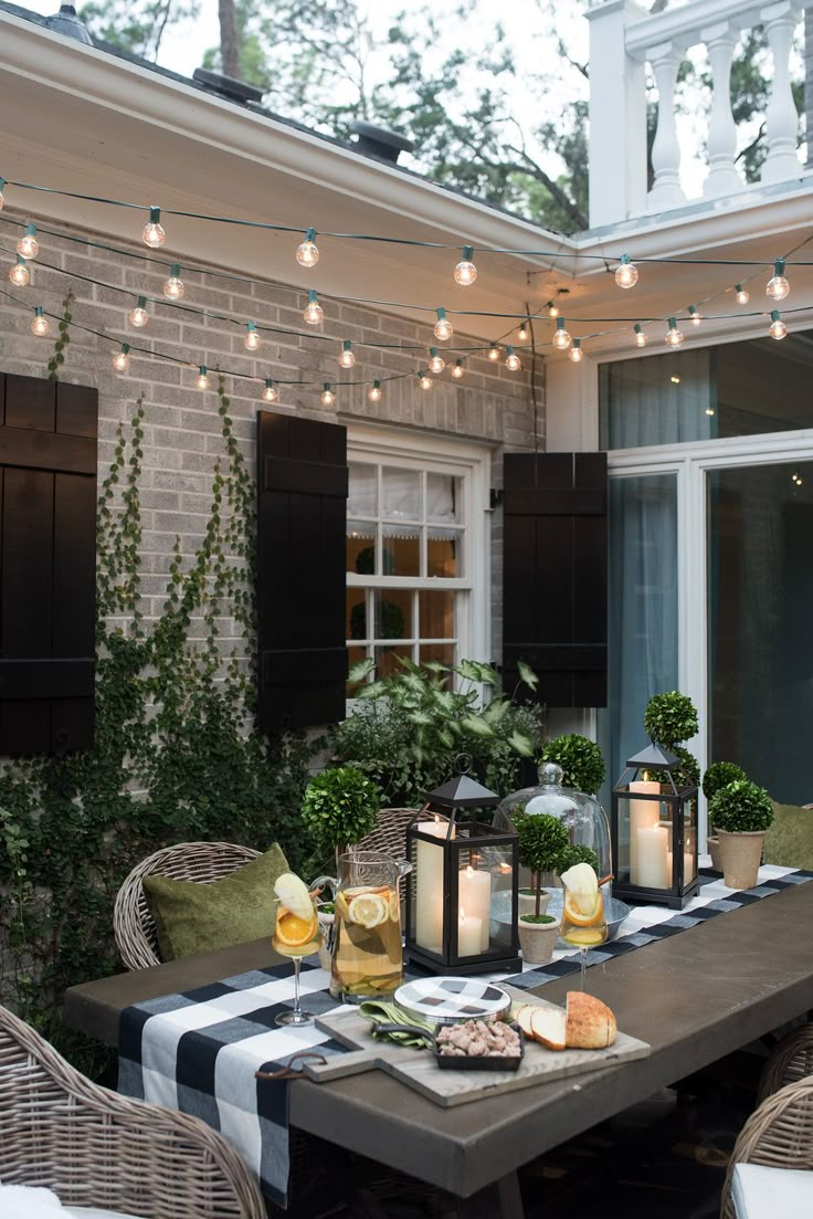 an outdoor dining table with candles and food on it