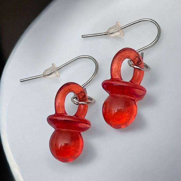 Bring fun and nostalgia to your jewelry collection with our pacifier earrings in bright red. Equipped with hypoallergenic stainless steel ear hooks, these 3.5 cm long earrings are very comfortable to wear and are ideal for sensitive ears. These fun pieces of jewelry are a real eye-catcher and are perfect for gender reveal parties, 90s themed parties or simply as an eye-catching accessory. Let yourself be convinced by their original touch and their excellent compatibility. 90s Accessories, Funny Earrings, Cute Slippers, Gender Party, Ear Hook, Reveal Parties, Gender Reveal Party, Long Earrings, Party Themes