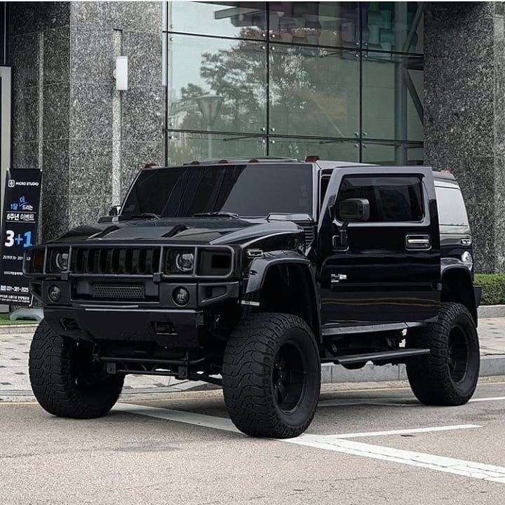 a black hummer truck parked in front of a building