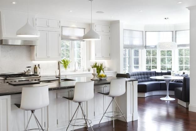 a kitchen with white cabinets and bar stools