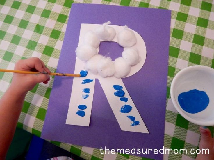 a child is painting the letter p with blue watercolors on paper while sitting at a table