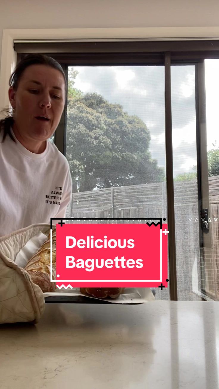 a woman sitting at a table in front of a window with the words delicious baguettes on it