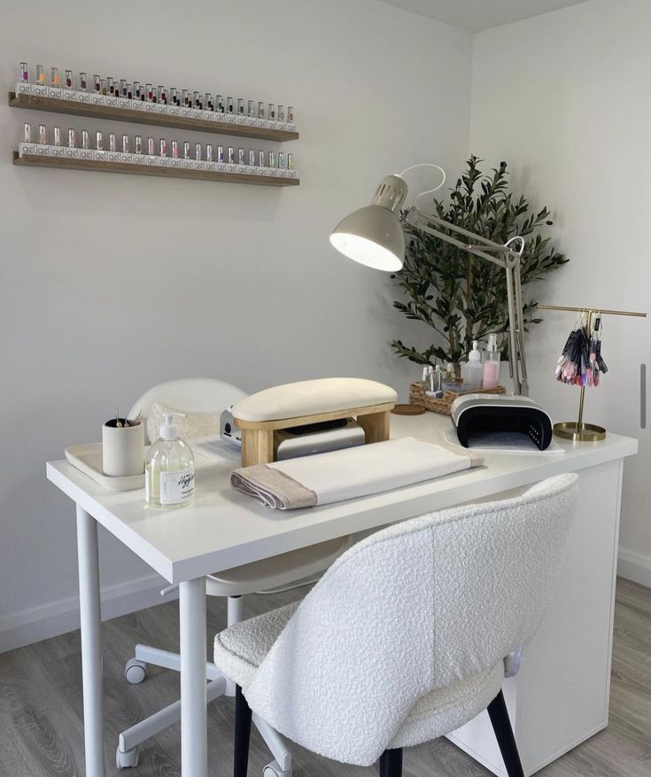 a white desk topped with a computer monitor next to a chair and shelf filled with bottles