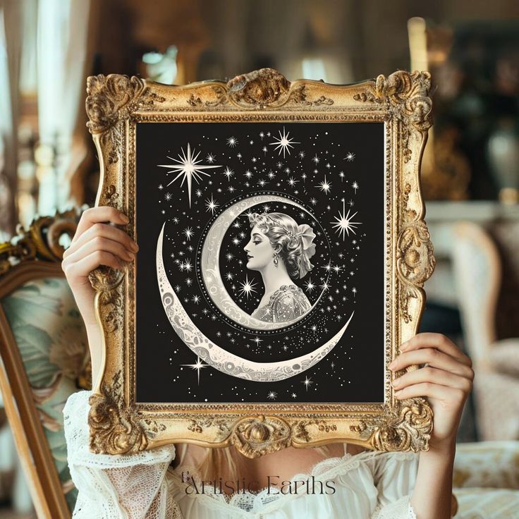 a woman holding up a framed art print with the moon and stars in her hair