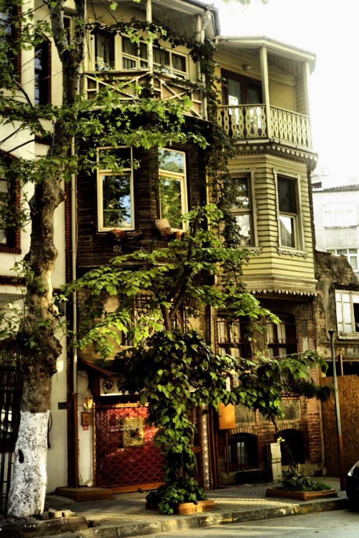 an old building with ivy growing on it's side and a car parked in front