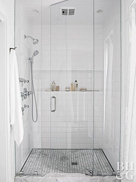 a white tiled bathroom with shower and sink