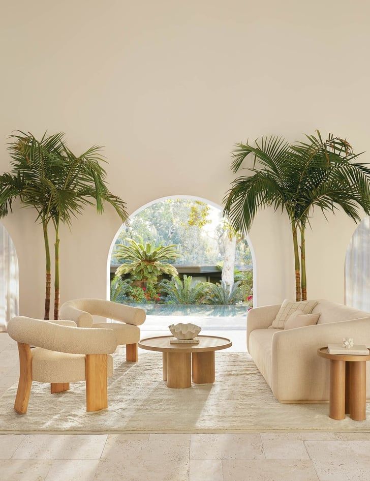 a living room filled with furniture and lots of palm trees in the middle of it