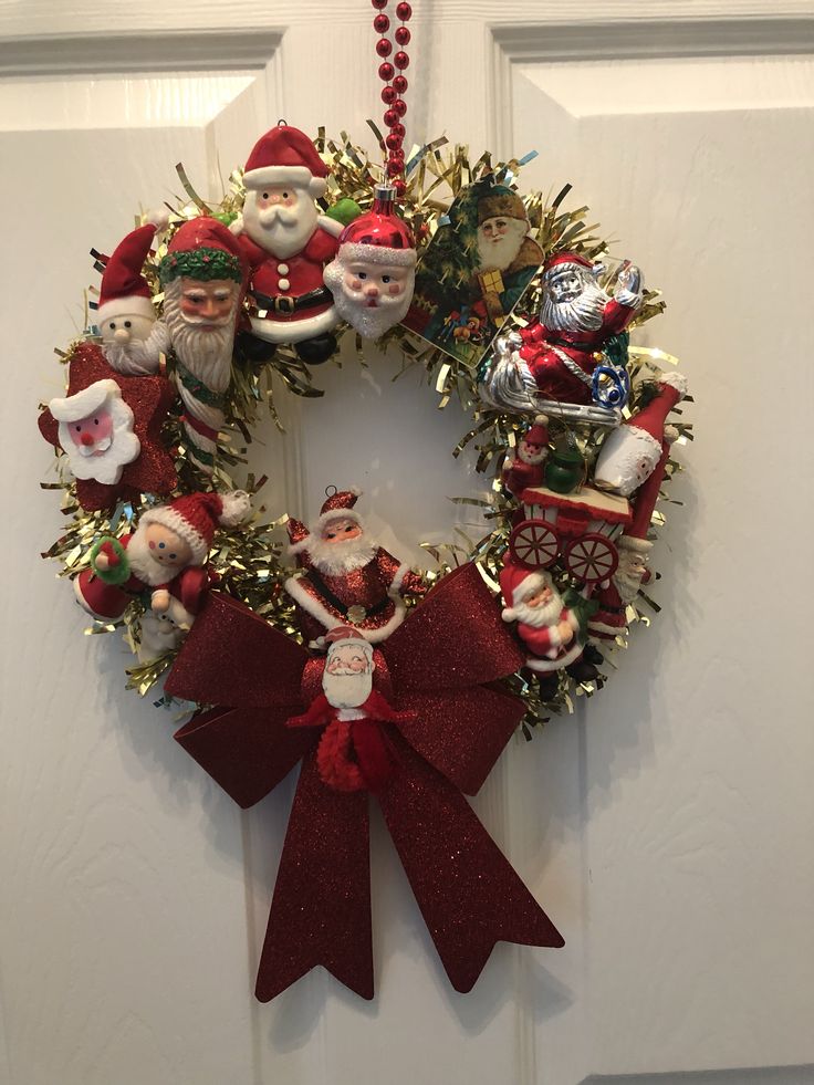 a christmas wreath with santa claus and other ornaments hanging on the front door to welcome guests