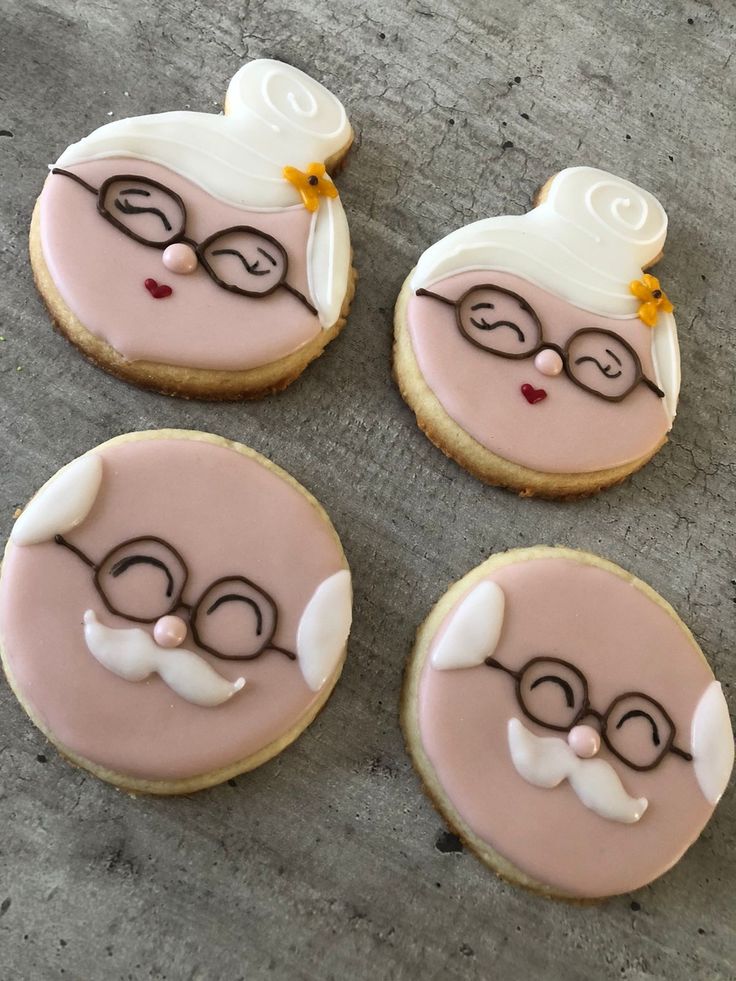 four decorated cookies sitting on top of a table