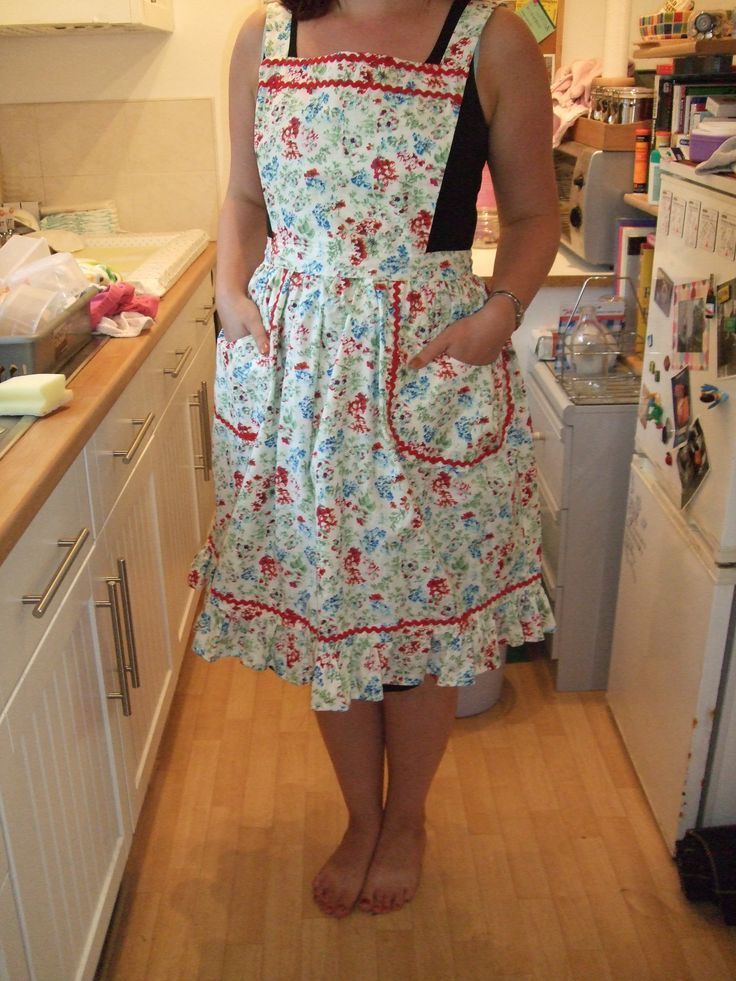 a woman standing in a kitchen wearing an apron