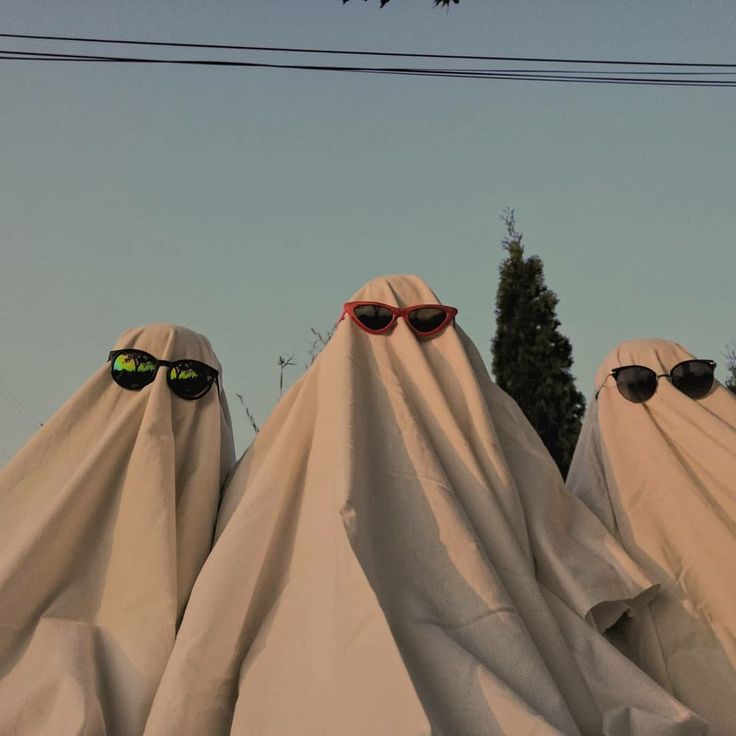 two people wearing sunglasses and covering them with white cloth