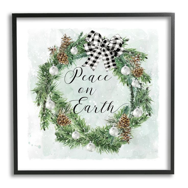 a christmas wreath with pine cones and white balls on it is framed in black frame