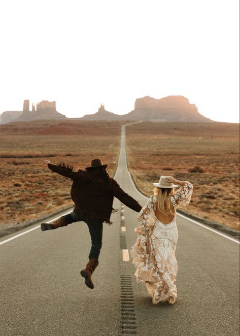 two people running down the middle of an empty road