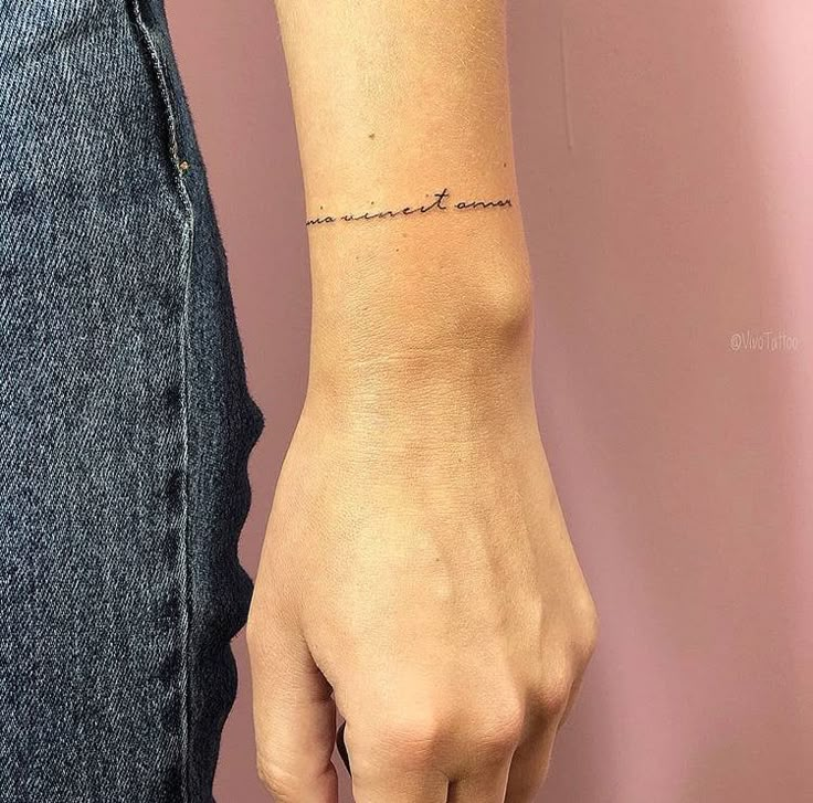 a woman's wrist with the word love written in cursive writing on it