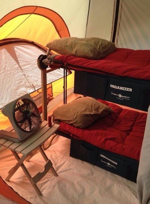 two bunk beds in a tent with an air vent and fan on the floor next to them