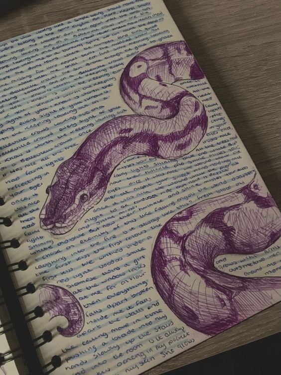 an open notebook with two purple snakes on it