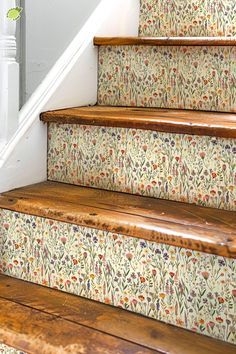 the stairs are decorated with floral wallpaper and wooden handrails, along with carpeted flooring