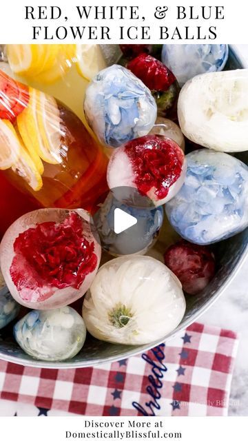 red, white and blue flower ice balls are in a bowl on a checkered tablecloth