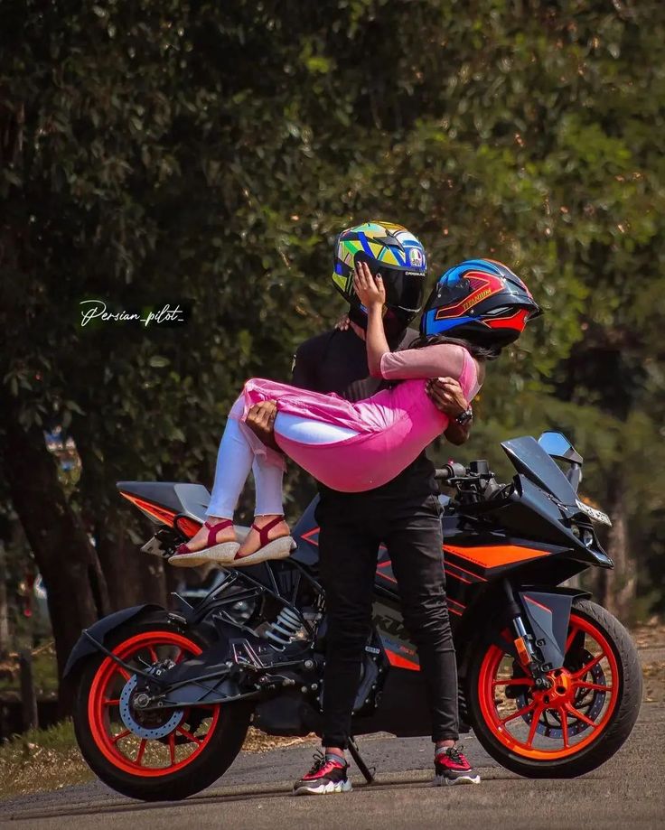 a man riding on the back of a motorcycle next to a woman wearing a helmet