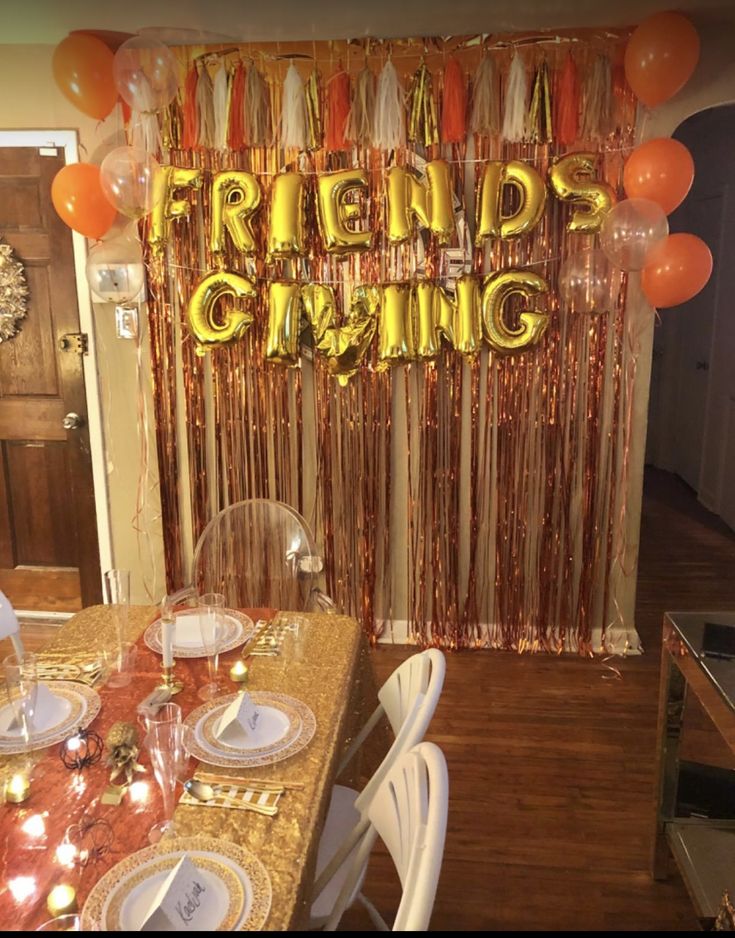 a dining room table set for dinner with balloons and streamers