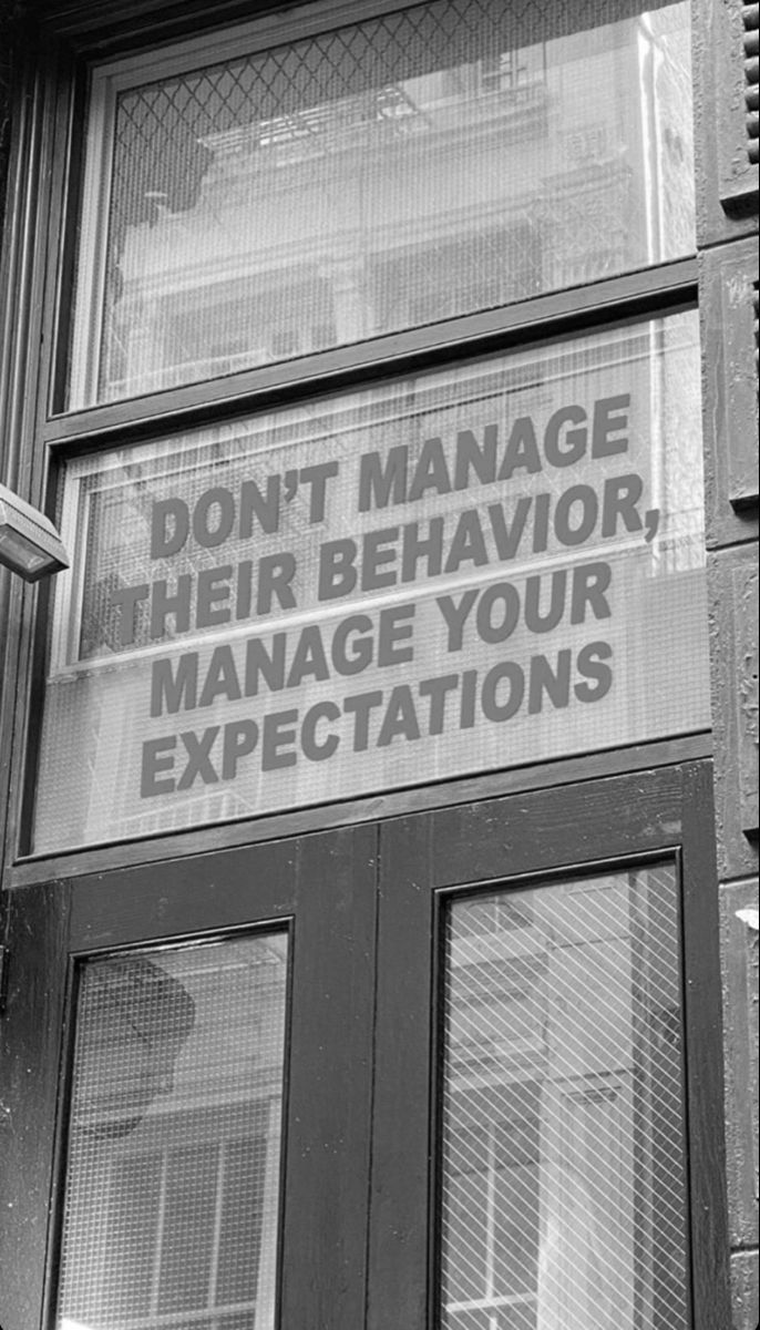 a sign on the side of a building that says don't manage their behavior manage your expectations