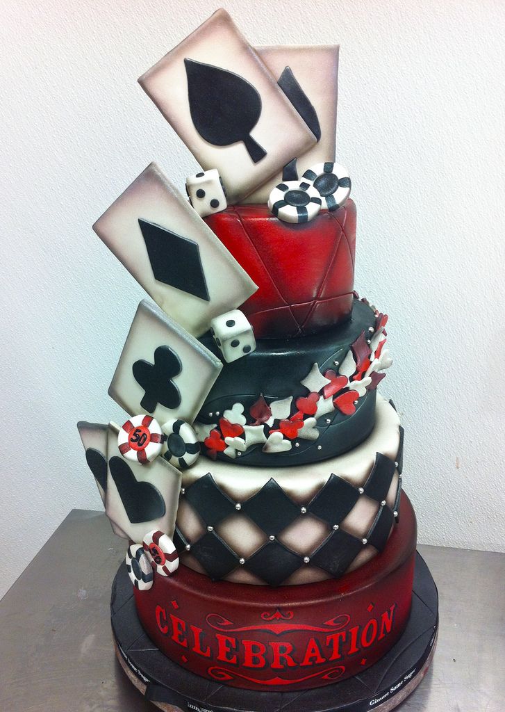 a multi layer cake decorated with playing cards and dice