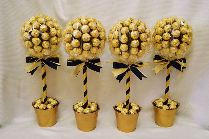 four vases filled with chocolate covered candies and wrapped in twine, sitting next to each other