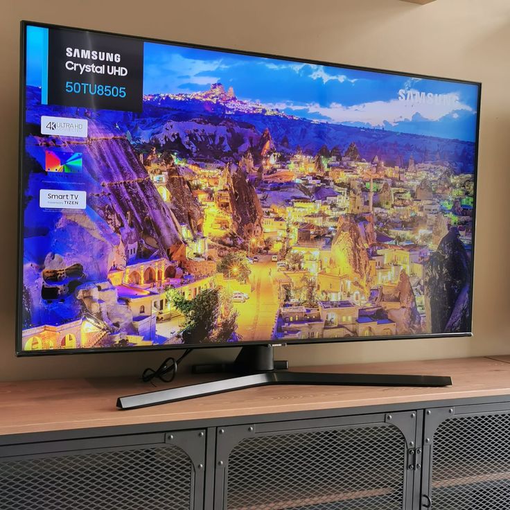 a flat screen tv sitting on top of a wooden table