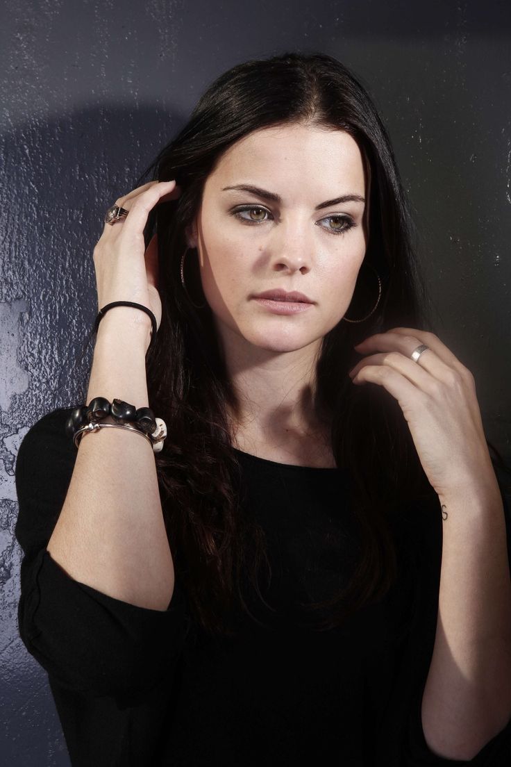 a woman in black shirt holding her hand near her head