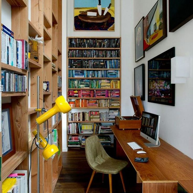 a room with bookshelves, desk and chair in it