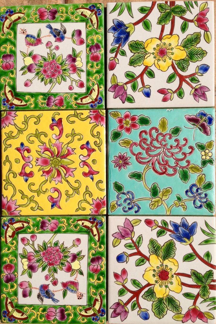 four different colored tiles with flowers and leaves on them, all painted in different colors