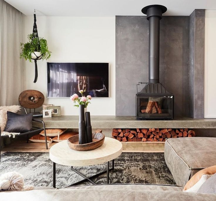 a living room filled with furniture and a fire place next to a wall mounted tv