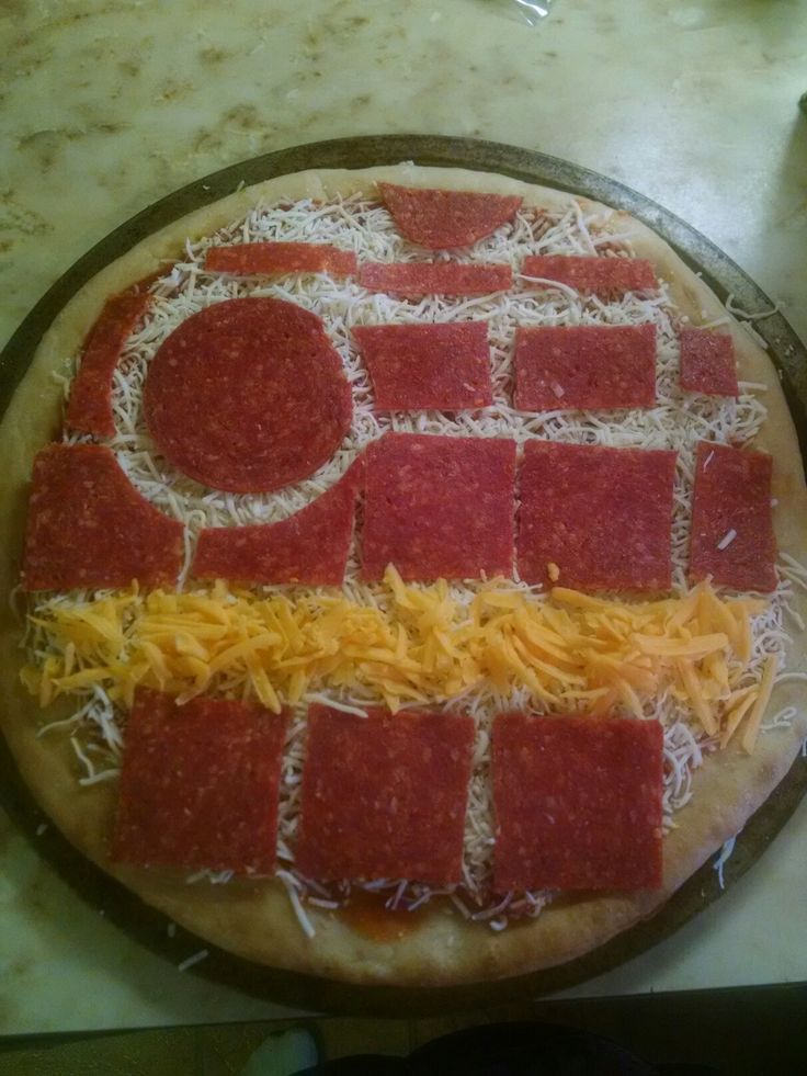 a pizza with cheese and pepperoni on it is sitting on a counter top, ready to be cut into pieces