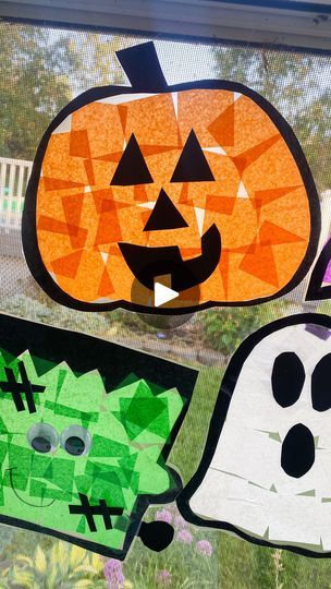 three paper cut out pumpkins and ghost faces on a window sill in front of a house